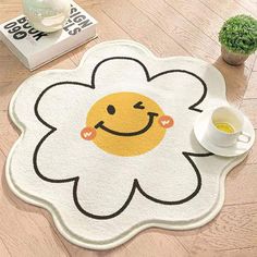 a white rug with a smiley face on it and a cup of coffee next to it