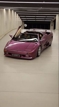 a purple sports car parked in a parking garage