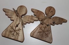 two wooden angel ornaments sitting on top of a table