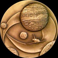 a bronze medal with an image of the sun and planets