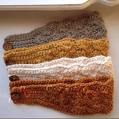 four crocheted headbands in various colors and sizes on a white surface