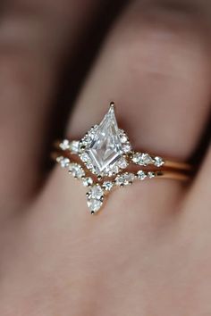 a woman's hand with an engagement ring on it and a diamond in the middle