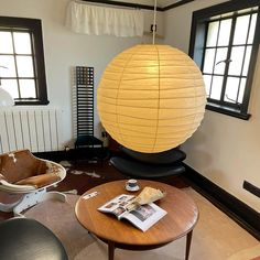 a living room filled with furniture and a large yellow lantern hanging over the top of it