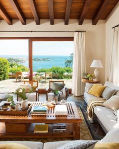 a living room filled with furniture and a large window overlooking the ocean in front of it