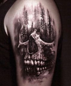 a man's arm with a skull and trees tattoo on the upper half of his arm