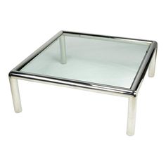 a square glass table with metal legs on a white background for use as a coffee table or side table