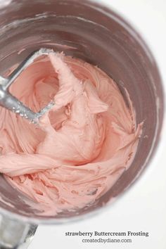 a close up of a mixer with pink frosting