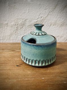 a ceramic container sitting on top of a wooden table