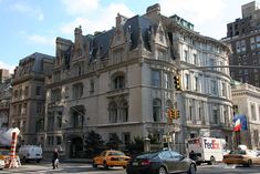 an old building with many windows and cars on the street