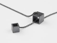 Two open cubes. Innovate design. The small cube slides through the big cube. The pendant and the necklace are made from 925 Sterling silver. The necklace has no closure behind the neck because the cubes can be moved into each other to open and close the necklace. The necklace has a length of about 82 cm (32 inch). The cube has a side legnth of about 9 mm (0,35 inch). In the shop we also offer the matching rings and earrings (have to be ordered separately). A perfect gift. Accordingly, the piece of jewelry is always ready gift packaged in a jewelry box.