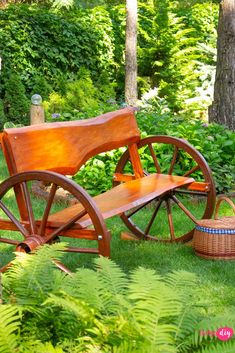 a wooden bench sitting in the grass next to a tree