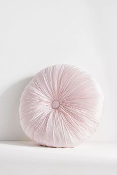 a white round pillow sitting on top of a table