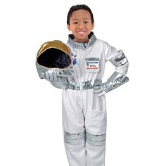 a little boy in an astronaut suit holding a helmet on his hand and smiling at the camera