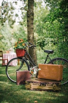 a bicycle parked next to a trunk with flowers in it