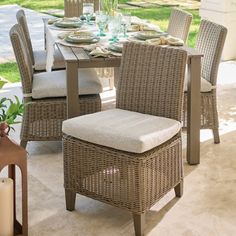 an outdoor dining set with wicker chairs and a table on the outside patio area