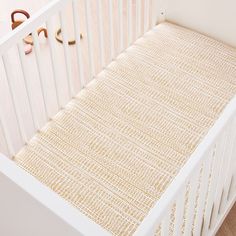 a white crib with a beige rug on the floor