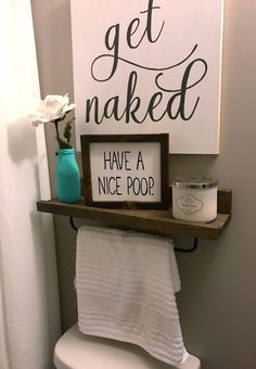 a toilet with a sign above it that says get naked have a nice poop