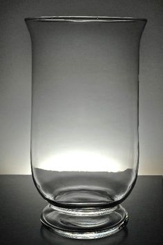 a clear glass sitting on top of a black table next to a white light behind it