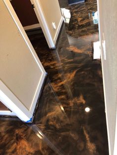 a hallway with black marble floors and white doors