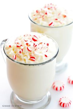 two glasses filled with whipped cream and candy canes