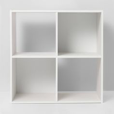 a white book shelf with four sections on each side and one section missing from the other