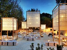 an outdoor seating area is lit up with candles