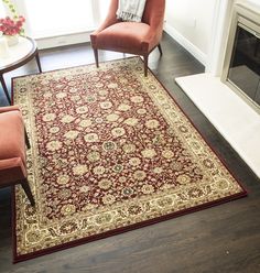 a red and gold rug with a chair in front of a window on a hardwood floor