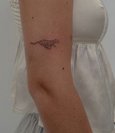 a woman's arm with a tattoo on it that is shaped like a lizard