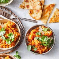 three bowls filled with food next to slices of flatbreads and pita bread