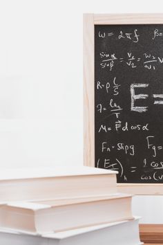 a blackboard with some writing on it next to two books and a pencil in front of it