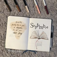 an open book sitting on top of a carpet next to some markers and pencils