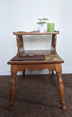 a small wooden table with a potted plant sitting on it's top shelf