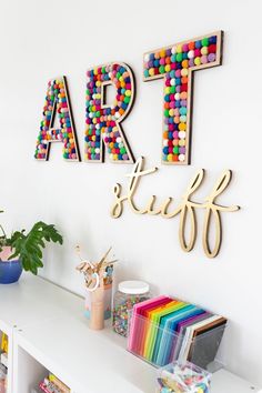 the wall is decorated with art letters and colorful beads on it's sides, along with bookshelves