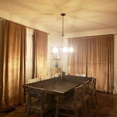 a dining room table with four chairs and a chandelier