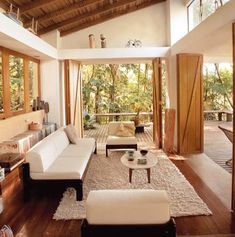 a living room with wooden ceilings and white furniture