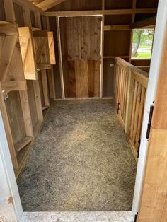 the inside of a horse trailer with hay on the floor and stalls in the back