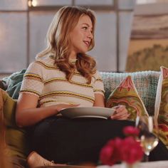 a woman sitting on a couch reading a book