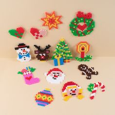 christmas decorations made out of perler beads on a white surface, including santa and other holiday related items