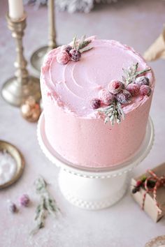 a pink frosted cake sitting on top of a table