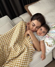 a woman holding a baby wrapped in a blanket