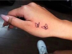 a small butterfly tattoo on the left wrist