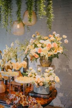 a table topped with lots of vases filled with different types of flowers and greenery