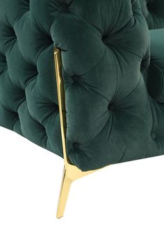 a green velvet chair with gold legs