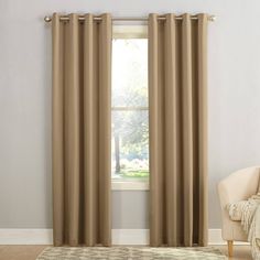 a living room with beige curtains and a white chair in front of a large window