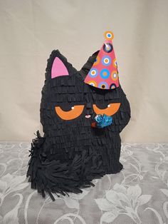 a black cat with a party hat on it's head