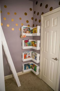 a child's room with polka dot wallpaper and white bookshelves in the corner