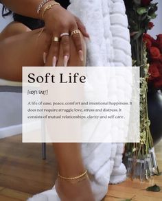 a woman sitting on top of a white chair next to a pile of towels and rings