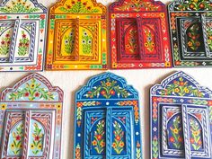 colorful painted doors are arranged on the wall