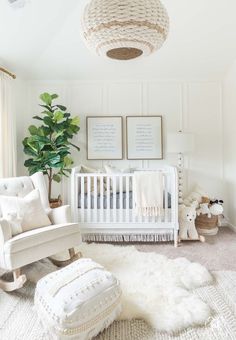 a white crib in the corner of a room with two pictures on the wall