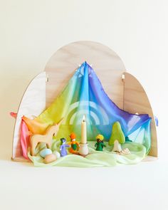 a wooden shelf with candles and figurines on it in the shape of a tent